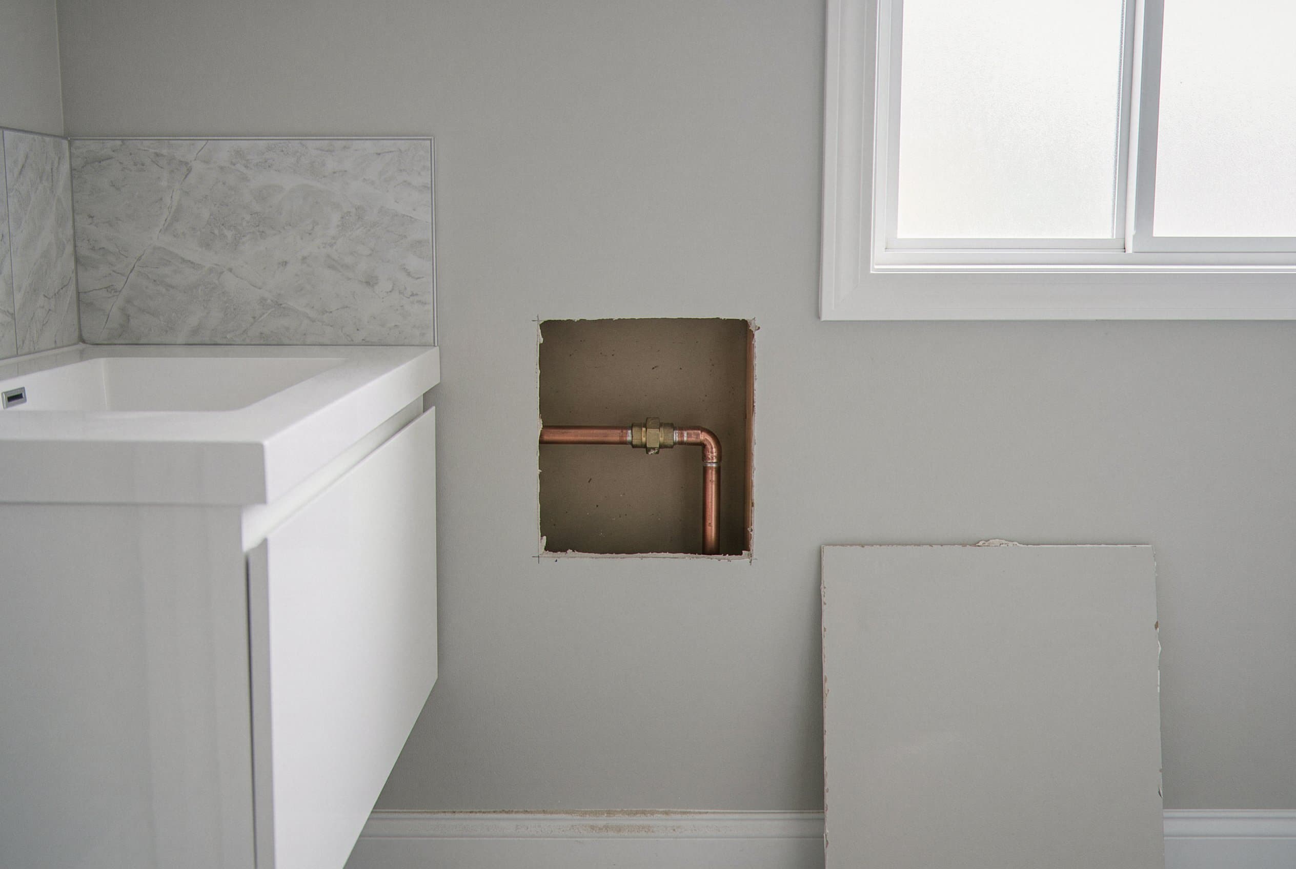 Wall opened to expose burst supply line